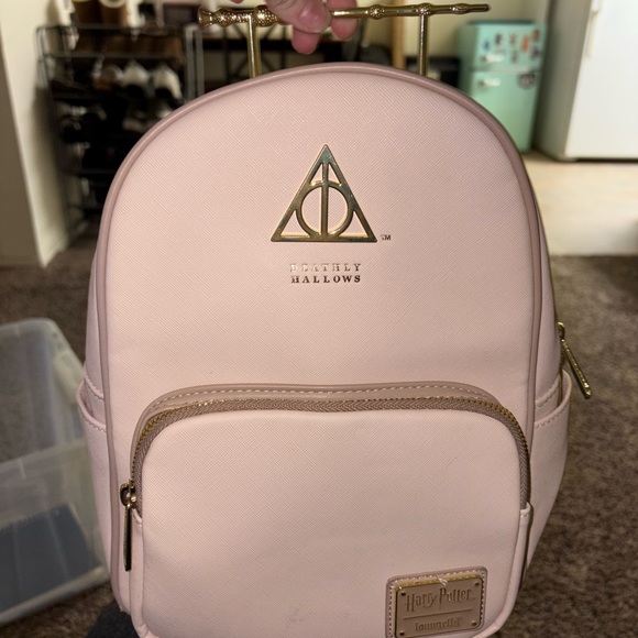 deathly hallows loungefly mini backpack x Harry Potter Pink Elder Wand Harry learns on his eleventh birthday that he is the orphaned son of two powerful wizards and possesses unique magical powers of his own Harry Potter VS Voldemort Duel